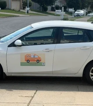 White car with company branding on the driver door